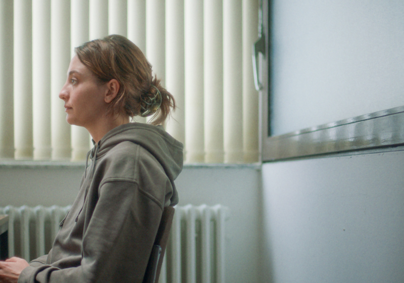 Une femme est assise, elle est face à un policier hors du cadre